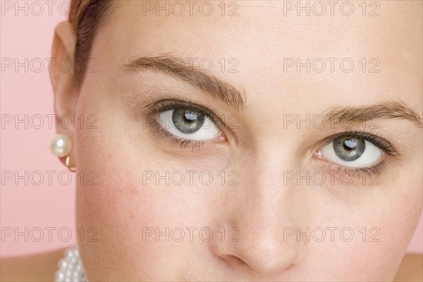 Close up of woman wearing pearls.