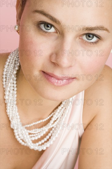 Close up of woman wearing pearls.