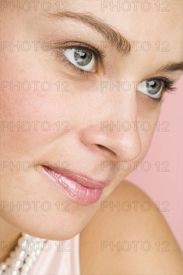 Close up of woman wearing pearls.