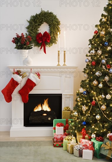 Christmas tree with presents and fireplace with stockings.