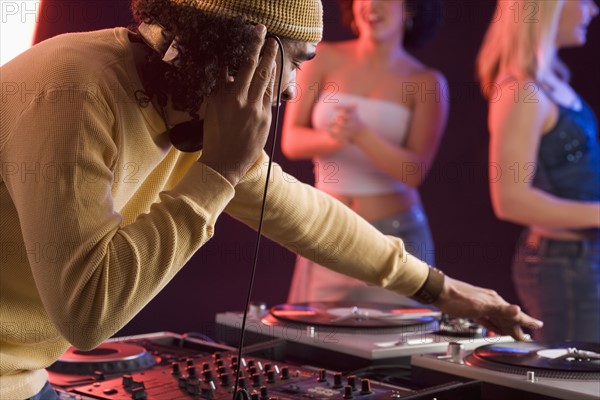 Young man playing music at a dance club.