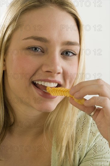 Portrait of woman eating a French fry.