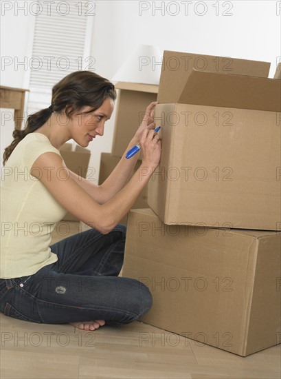Woman marking boxes on moving day.