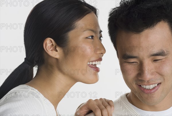 Woman telling man a secret.