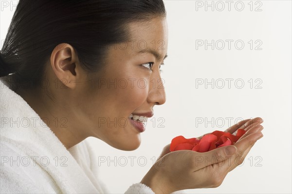 Woman smelling rose petals.