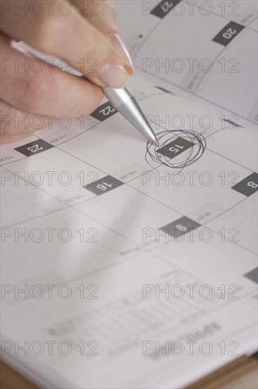 Woman marking day on calendar.