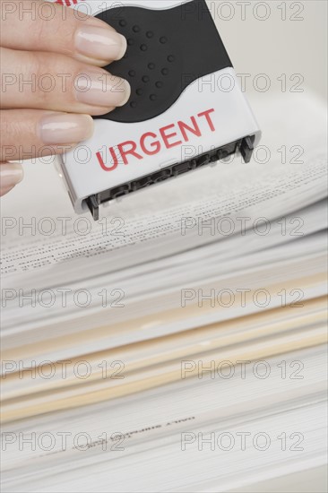Woman stamping paperwork as urgent.