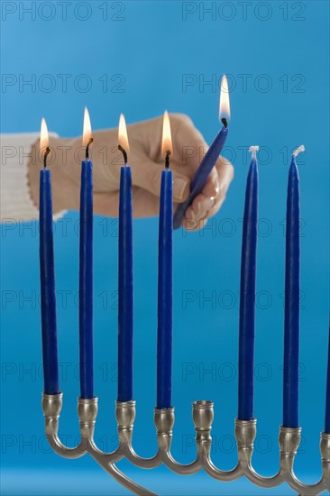 Woman lighting a Menorah.