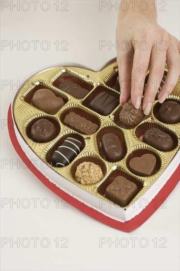 Woman taking a piece of candy from box.