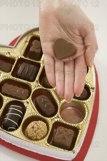 Woman taking a piece of candy from box.