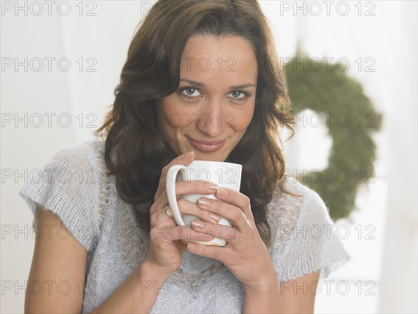 Closeup of woman sipping from a mug.