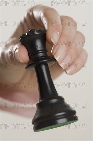 Woman holding chess piece.