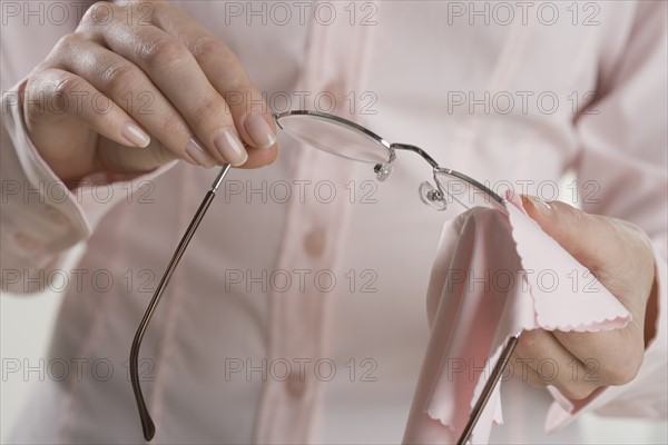 Female hands cleaning eyeglasses.