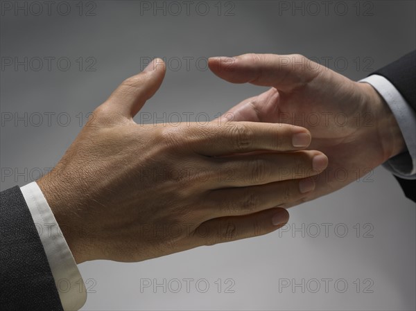 Two men about to shake hands.