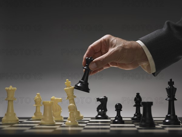 Businessman moving chess piece.