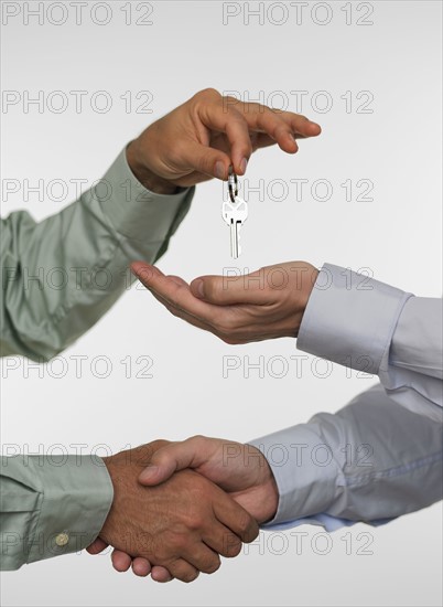 Two men closing deal and handing over keys.