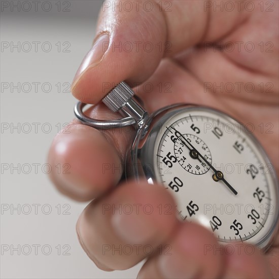 Hand holding stop watch.