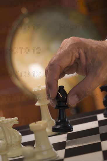 Hand moving chess piece.