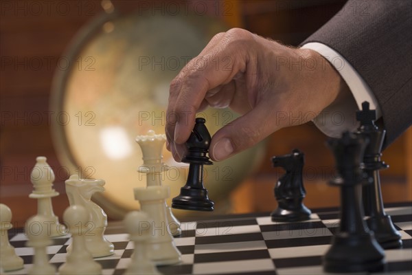 Businessman moving chess piece.