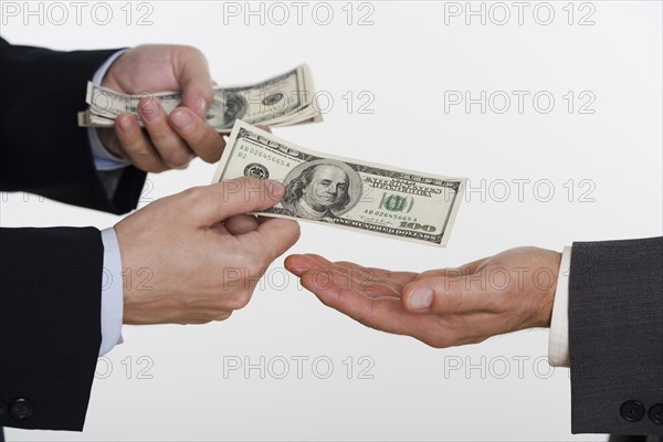 Businessman giving money to a man.