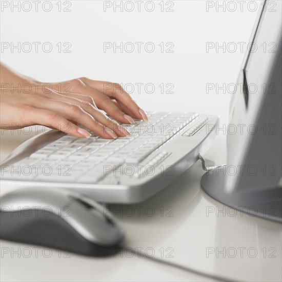 Close up of woman typing on computer keyboard.