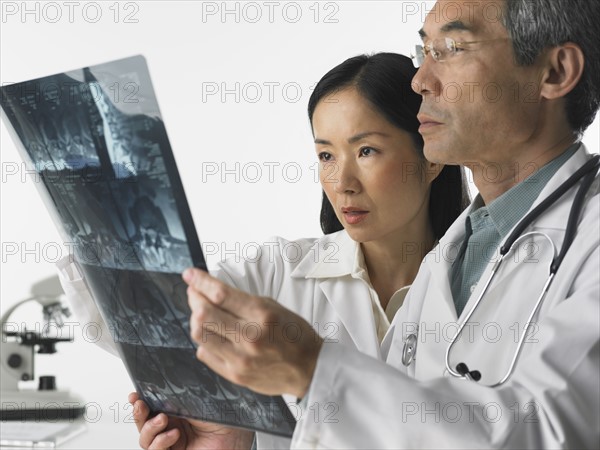 Male and female doctors looking at x-rays.