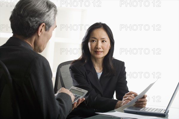 Asian businesswoman talking to businessman.
