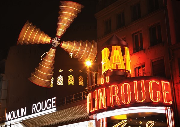 Neon signs in urban scene, Moulin Rouge, Paris, France.