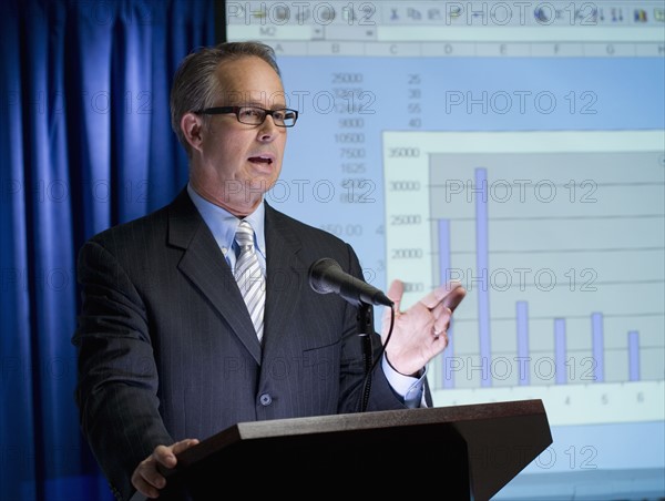 Businessman speaking at podium.