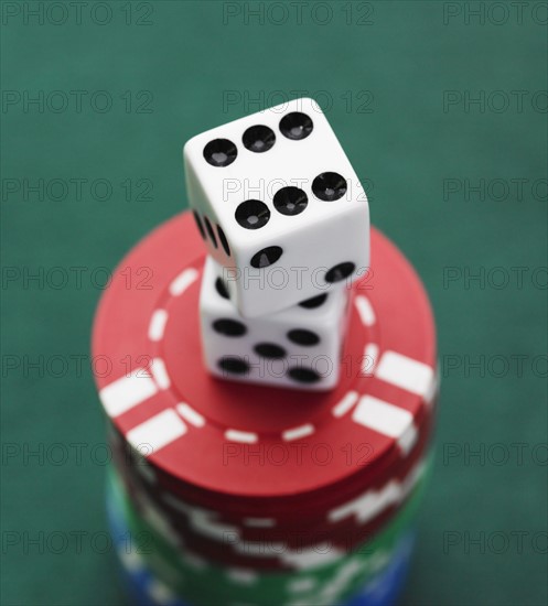 Close up of dice on stack of poker chips.