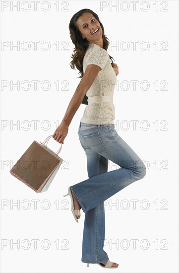 Studio shot of woman with holding shopping bag.