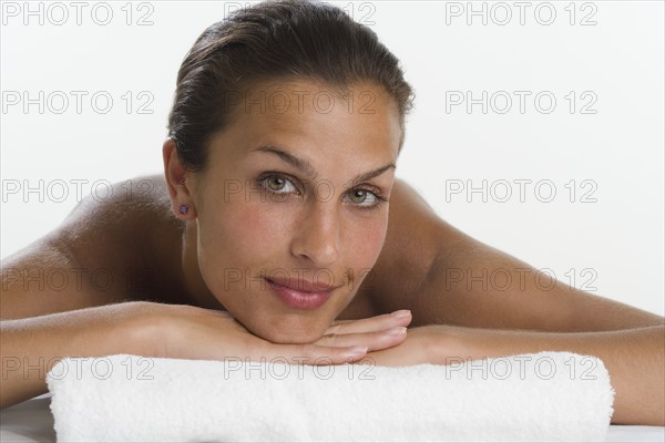 Close up of woman leaning chin on hands and towel.