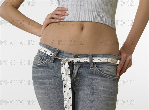 Woman with bare midriff using tape measure as belt.