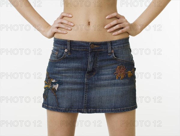 Close up of woman with bare midriff wearing mini skirt.