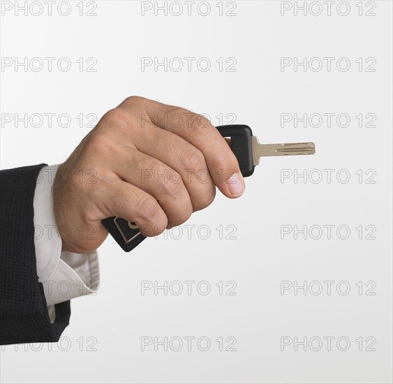 Studio shot of businessman holding car keys.