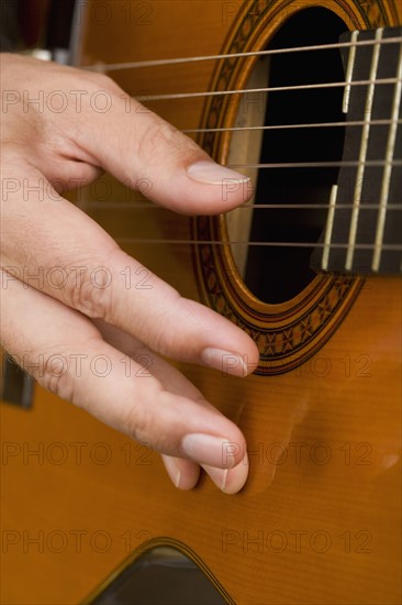 Close up of man's hand playing guitar.