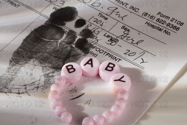 Close up of baby bracelet and birth certificate.