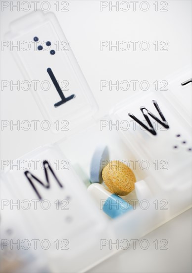 Close up of pills in weekly organizer.