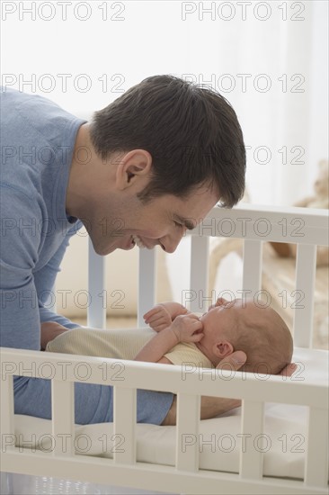 Father smiling at newborn baby.