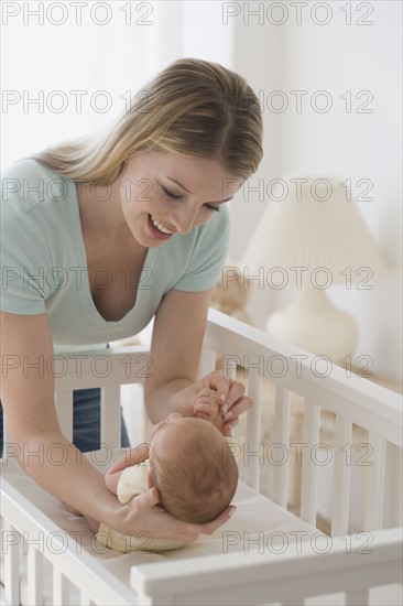 Mother smiling at newborn baby.
