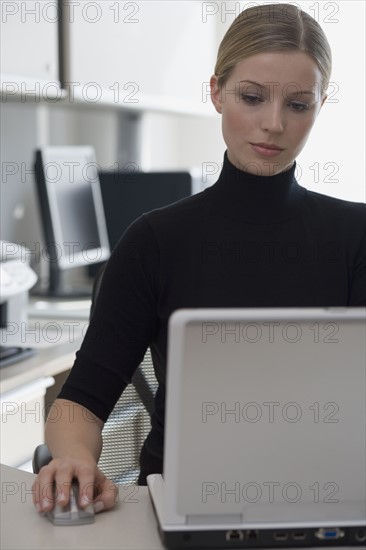 Businesswoman using wireless computer mouse.
