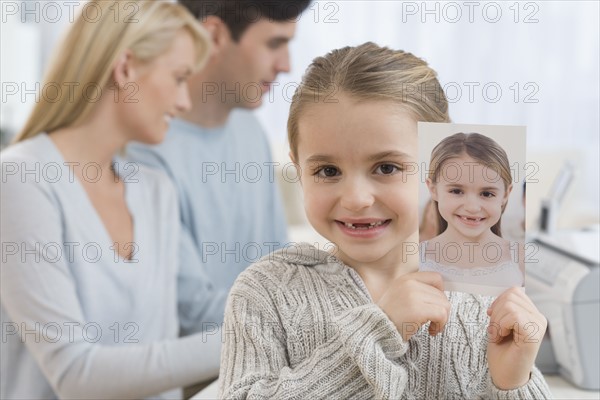 Portrait of girl holding picture of self.