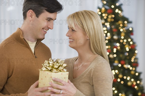 Couple holding Christmas gift.