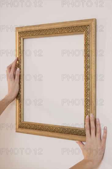 Woman hanging empty picture frame.