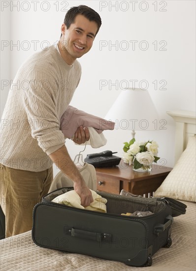 Man unpacking in hotel room.