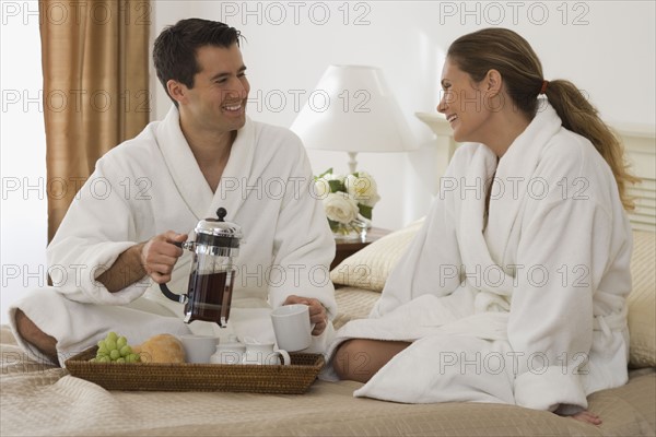 Couple eating breakfast in bed.