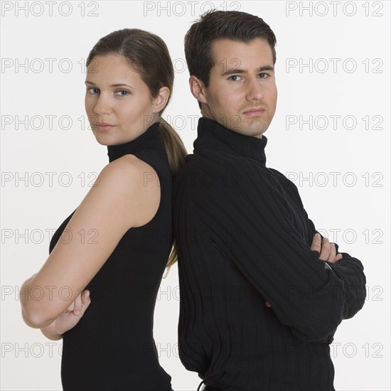 Studio shot of couple standing back to back.