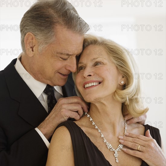 Senior man giving diamond necklace to wife.