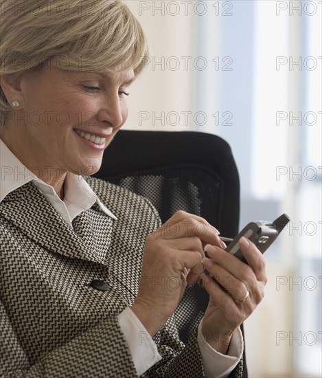 Senior businesswoman using electronic organizer.