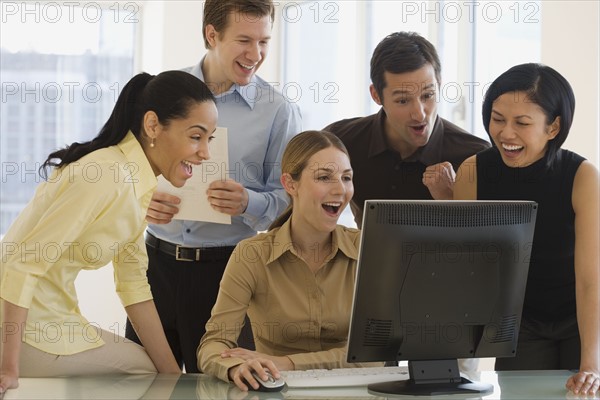 Group of businesspeople looking at computer.